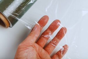 mano che tiene pellicola per alimenti